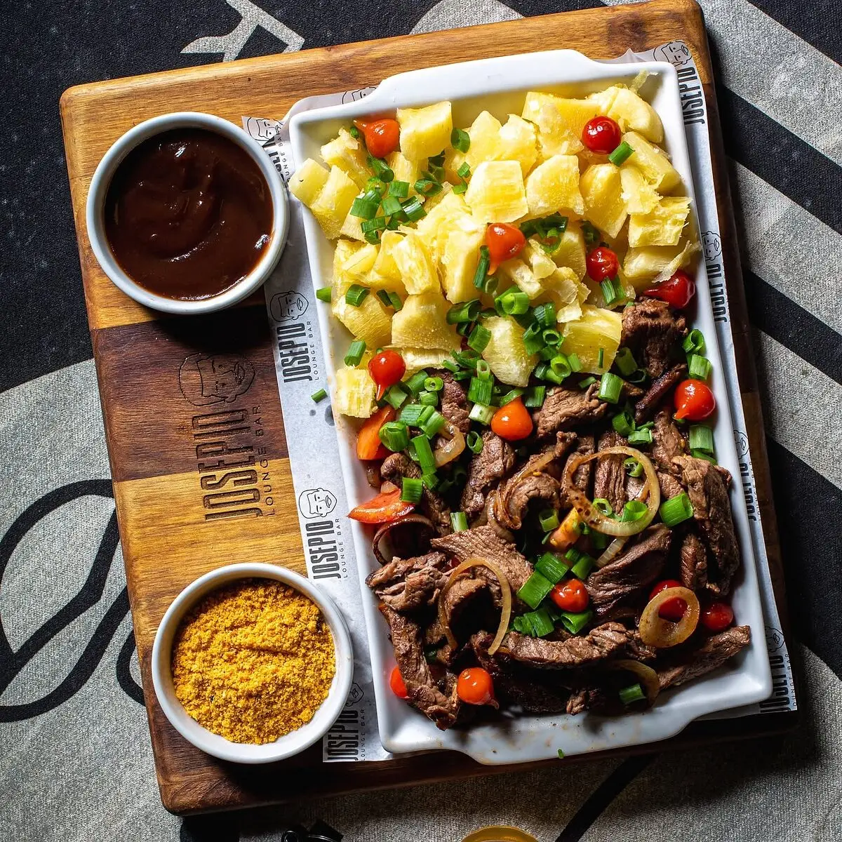 Carne acebolada com mandioca, pimenta biquinho e farofa na tábua do Josepio