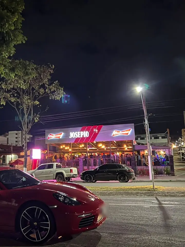 Fachada iluminada do Josepio Lounge Bar à noite na Av. João Alves do Nascimento