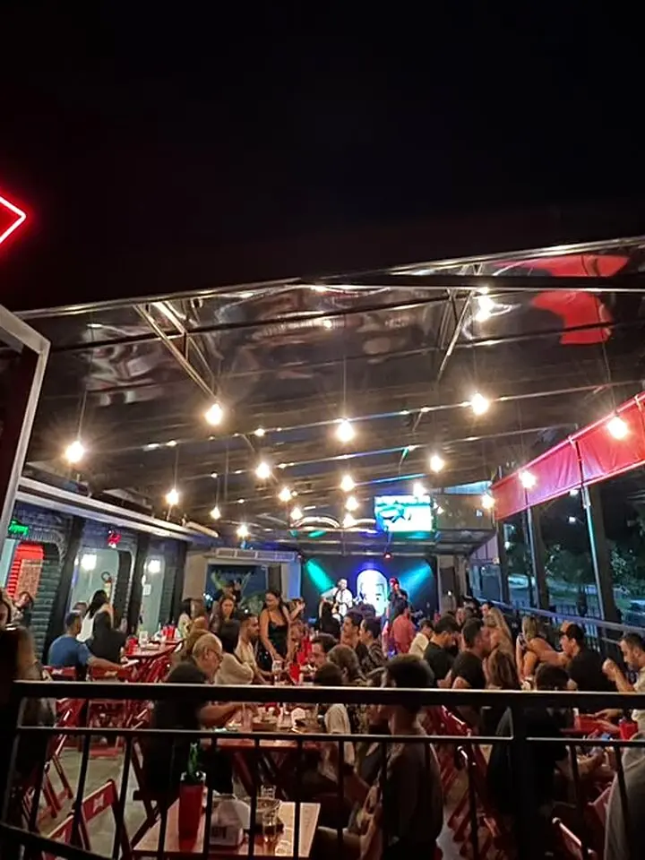 Salão principal do Josepio lotado à noite com lâmpadas acesas