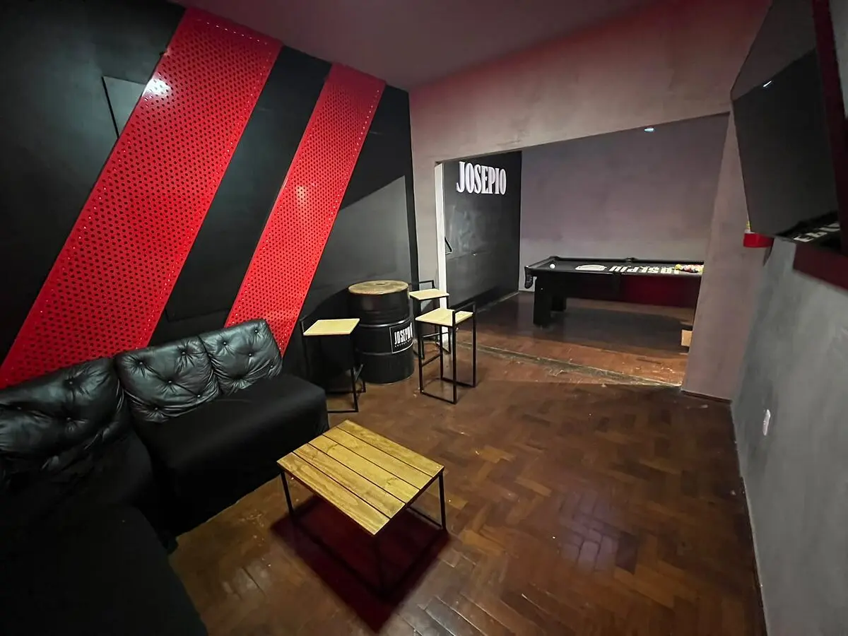 Mesa de sinuca da Sala VIP com TV e lounge ao fundo